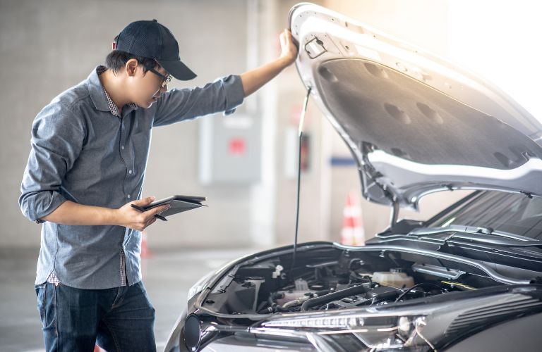 Car mechanic inspecting the engine of a vehicle