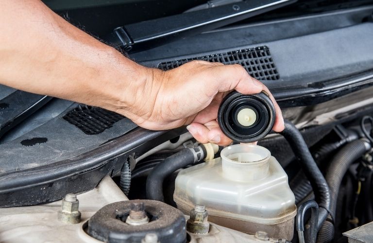 A man pouring transmission fluid